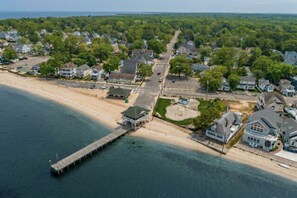 Une zone résidentielle côtière comprenant des maisons, une plage et une jetée.