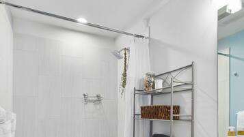 A modern bathroom with a bathtub, toilet, and shower area.