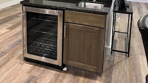 A kitchen with wooden cabinets, a built-in oven, a granite countertop, and a stainless steel sink.