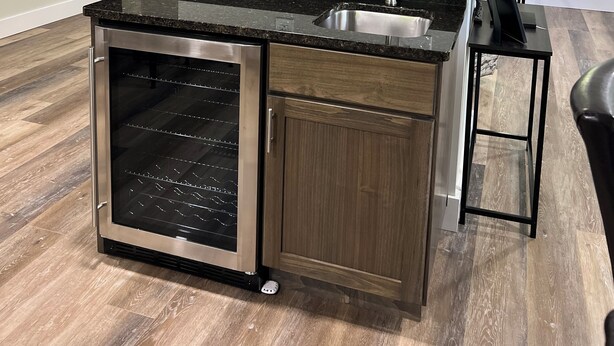 Una cocina con armarios de madera, horno empotrado, encimera de granito y pileta de acero inoxidable.