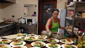 A kitchen with multiple plates of food, a stove, and a refrigerator. - Cabinas Arribadas  (Cuajiniquil)