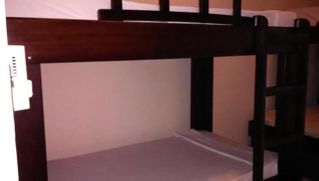 A bunk bed with a wooden frame and a mattress.