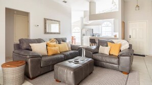 A spacious living room with a grey sectional sofa, a wooden coffee table, and a patterned rug. - Quiet Getaway to Tampa & Orlando (Mulberry)