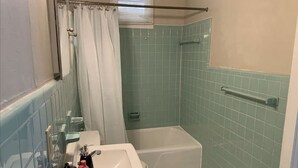 Ein Badezimmer mit Dusche, Waschbecken und Toilette.