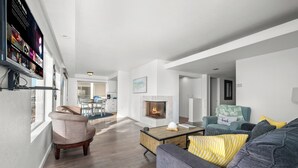 Una sala de estar moderna con chimenea, un sofá, una mesa de centro y un televisor montado en la pared.
