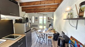 A compact kitchen with a microwave, refrigerator, and a dining area with a table and chairs. - Meschers sur Gironde - TOP HOLIDAY VILLA - IDEAL FAMILY RESIDENCE (MESCHERS SUR GIRONDE)