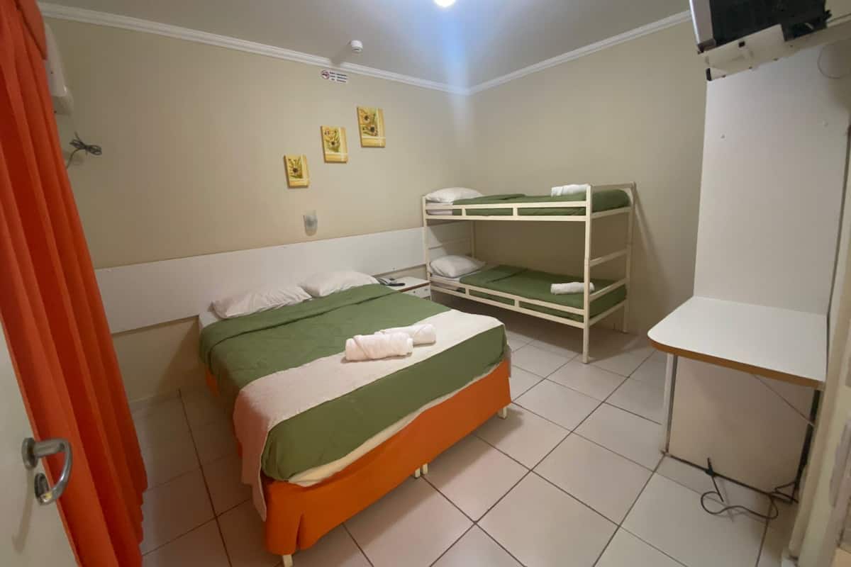 Un dormitorio con una cama individual, una litera, un escritorio y una cortina de ducha.