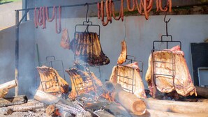 Ein Grill mit verschiedenen Fleischsorten, die über offenem Feuer zubereitet werden.