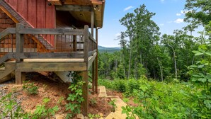 A wooden cabin with a balcony overlooking a forested area. - Romantic retreat with spectacular mountain view. (Blue Ridge)