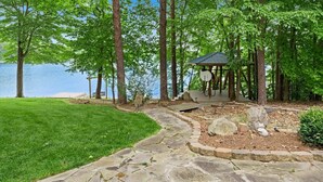 A stone pathway leading to a gazebo by a lake, surrounded by trees and a grassy area. - Grand Bay w/Hot Tub, 440' Shoreline & Optional Boat Rental (Mooresville)