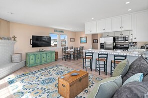 A modern kitchen with white cabinets, a built-in island, and stainless steel appliances.