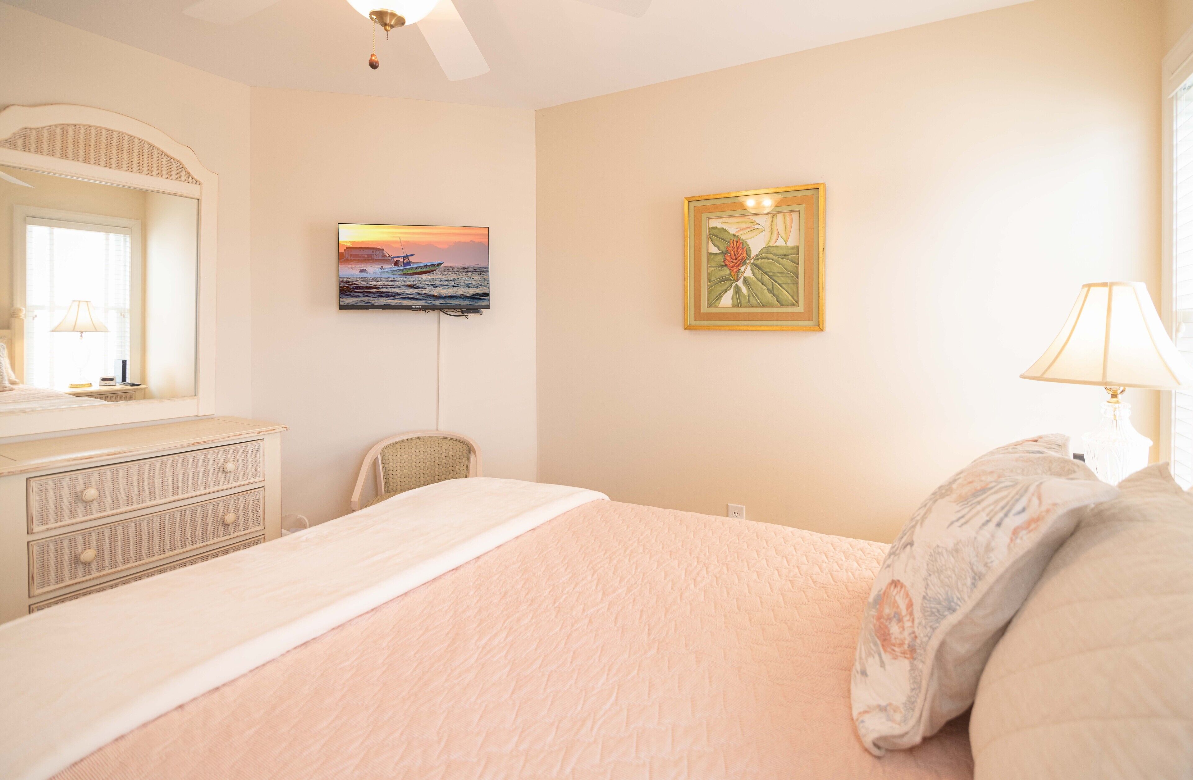 Un dormitorio con cama, cómoda, silla y decoración en la pared.