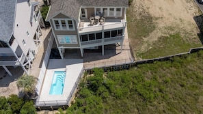 Une maison à plusieurs étages avec une piscine, un balcon et une vue sur la plage.