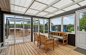A sunroom with a wooden deck, glass doors, and a bench. - Nice home in Hejls with WiFi (Hejls)