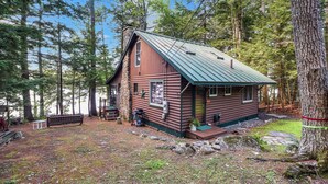 A log cabin with a metal roof, surrounded by trees. - Quintessential Maine cabin w/ private waterfront (Augusta)