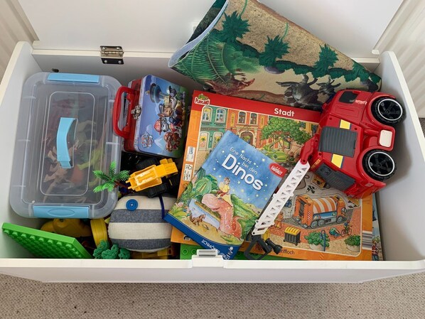 A drawer filled with toys, books, and storage containers.