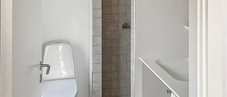 Een badkamer met toilet, douche en wastafel.