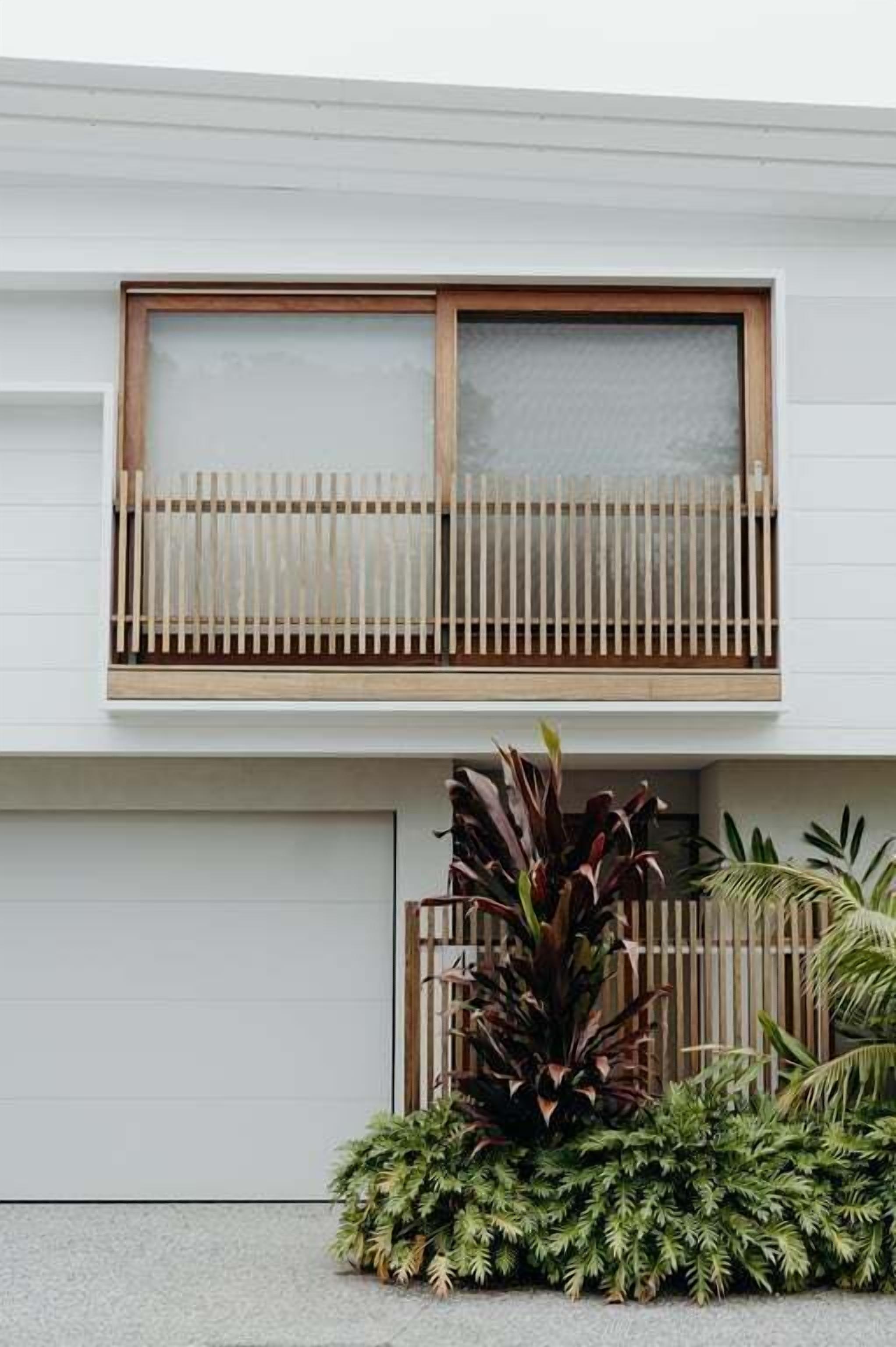 A modern building with a large window and a wooden fence.