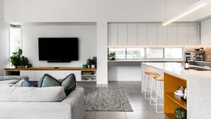 A modern living room with a flat-screen TV, a sofa, and a coffee table.