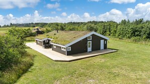 A modern house with a sloped roof, a deck, and a small outdoor seating area. - Pet friendly home in Saltum with WiFi (Saltum)