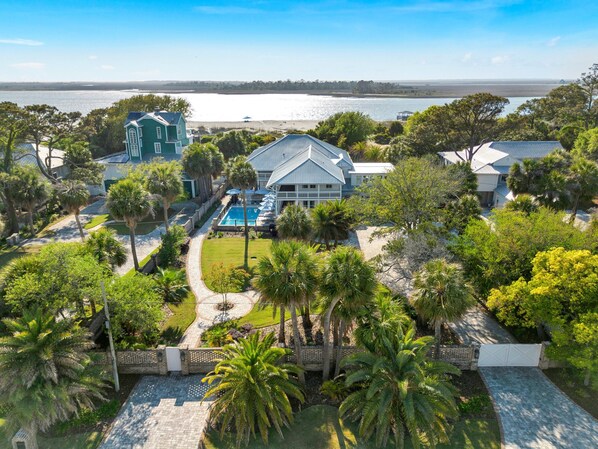 A resort with a swimming pool, a large house, and a view of the water.