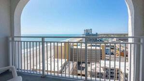 Een balkon met uitzicht op het strand en de stad.