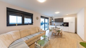 Un appartement moderne comprenant un salon, un coin repas et une cuisine.