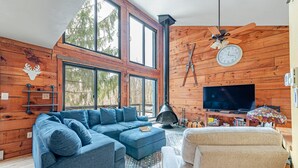 A modern living room with a sectional sofa, a television, and a fireplace. - 4 bed in Hidden Valley Resort, Slope View (Hidden Valley)