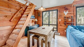 A wooden interior with a wooden staircase, a dining table, and a blue sofa. - 4 bed in Hidden Valley Resort, Slope View (Hidden Valley)