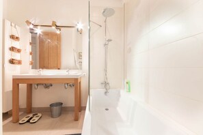 Un bagno con un mobile lavabo in legno, una vasca e una doccia.