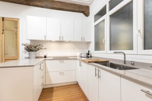 A modern kitchen with white cabinets, a wooden countertop, a stainless steel sink, and a window with frosted glass. - Amazing down town, near Guggenheim. Céntrico (BILBAO)
