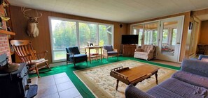 A spacious living room with a large window, a fireplace, and a television.