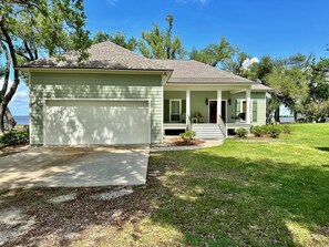 A single-story house with a garage, a covered porch, and a small front yard.