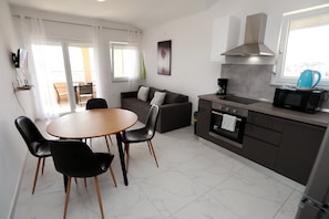 Une cuisine moderne avec un coin repas, un canapĂ© et une vue sur lâextĂ©rieur.