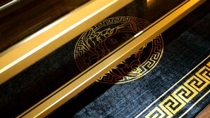 A close-up of a black and gold patterned carpet with a geometric design.