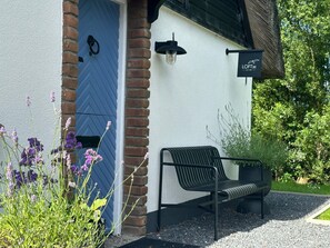 A building entrance with a blue door, a bench, and a sign reading 'LOFTZ'.