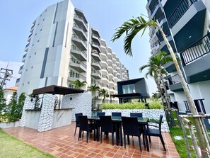 Residents enjoy balconies and terraces with outdoor space, a landscaped ground level with seating area, and a warm climate setting.