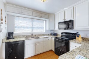 Features a granite countertop, stainless steel appliances, and a large window.