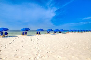 Relax on the beach with comfortable lounge chairs and umbrellas.