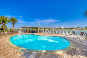 Relax by the pool surrounded by a wooden deck and lounge chairs.