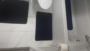 A modern bathroom with a white sink, toilet, and bathtub. There is a small potted plant on the countertop, and toiletries are visible. - Unique and Spacious 1BR Basement near Anthony Henday.  (Edmonton)