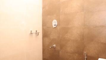 Ein Badezimmer mit Duschbereich, Toilette und Waschbecken.
