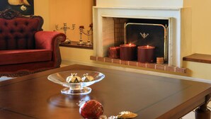 Una mesa de comedor con un cuenco de vidrio, un adorno rojo y una vela.