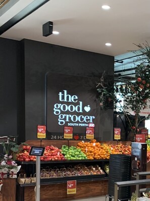 Ein Lebensmittelgeschäft innen, mit einem Schild, auf dem 'The Good Grocer South Perth' steht, und verschiedenen Obstsorten in der Auslage.