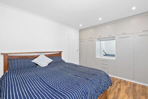 Ein Schlafzimmer mit Bett, Kleiderschrank und Fenster.