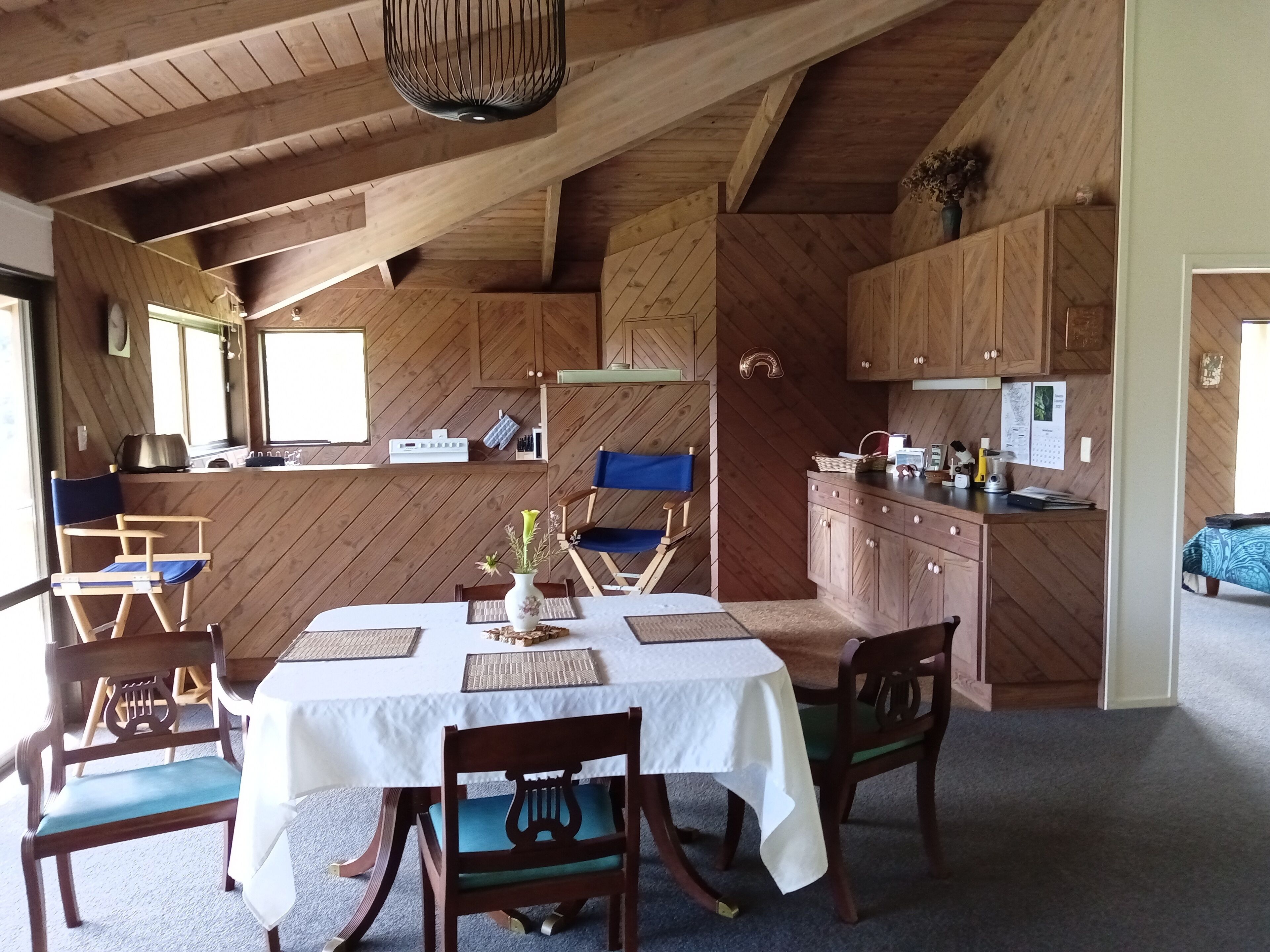 A rustic wooden interior with a dining area, kitchen, and seating space.