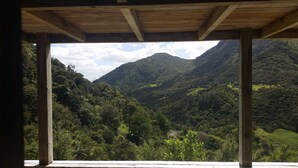 Una construcció de fusta amb vista a una vall exuberant i muntanyes.