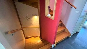A staircase with wooden steps and a red wall.
