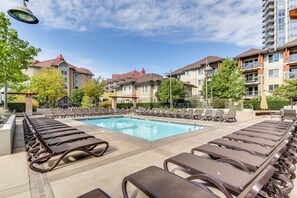 A poolside area with lounge chairs and a swimming pool.