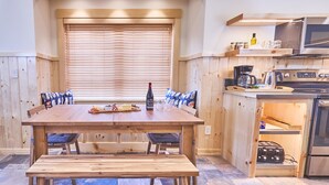 A wooden dining table with a bench, a bottle of wine, and snacks. - House on Metolius (Camp Sherman)